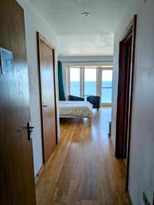 a room with a bedroom with a bed and a view of the ocean at cellar cove in Perranporth