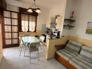 a kitchen and living room with a table and a couch at Appartamento Rosalba in Scalea