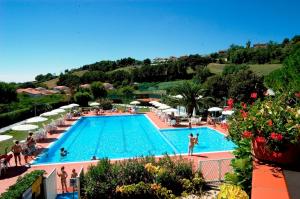 a large swimming pool with people standing around it at Villa trilocale CON SPIAGGIA E PISCINA incluse - Taunus Vacanze Villa Primule in Numana