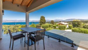 a table and chairs on a balcony with a view of the water at Villa Arthur in Kassiopi