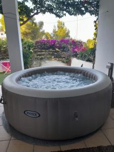 einen großen kreisförmigen Whirlpool auf einer Terrasse mit Blumen in der Unterkunft Peñiscola Bel Appartement de Vacances in Peñíscola