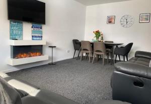 ein Wohnzimmer mit einem Sofa und einem Tisch mit einem Kamin in der Unterkunft Primrose Valley Bungalow in Filey