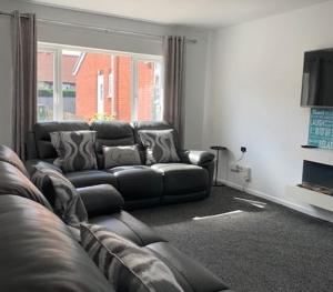 ein Wohnzimmer mit Sofa und Fernseher in der Unterkunft Primrose Valley Bungalow in Filey