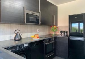 eine Küche mit schwarzen Geräten und einem Wasserkocher in der Unterkunft Primrose Valley Bungalow in Filey
