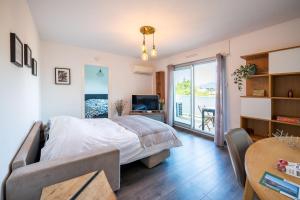 a bedroom with a bed and a television and a table at Eden Bleu, parking, piscine, tennis et soleil in Antibes