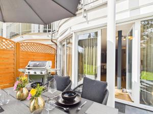 Un comedor con mesa y parrilla. en Hochwertige Ferienwohnung in Seenähe mit Terrasse & Vollausstattung, en Uhldingen-Mühlhofen
