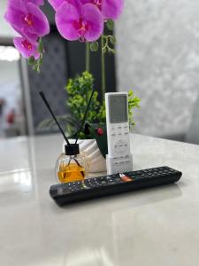 a remote control sitting next to a vase with flowers at Cozy Luxury in Samarkand