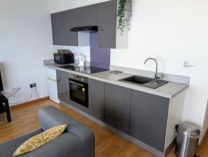 a kitchen with a sink and a couch in a room at cellar cove in Perranporth