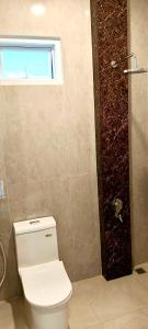 a bathroom with a toilet and a window and a shower at Classic Resort Puncak in Campaka +19 photos