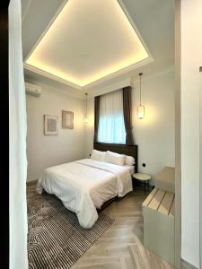 a bedroom with a white bed and a window at Classic Resort Puncak in Campaka