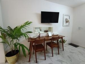 a dining room with a table and a tv on a wall at Casa Mercedes in Valladolid