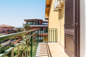 a balcony with a door and a view of a building at GuestHost - Eden Green Oasis in Giardini Naxos