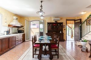 a kitchen with a table and chairs in a room at GuestHost - Eden Green Oasis in Giardini Naxos