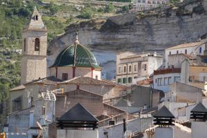 a group of buildings with a church and a mountain at Gaiamoment La casa la panadera in Alcalá del Júcar