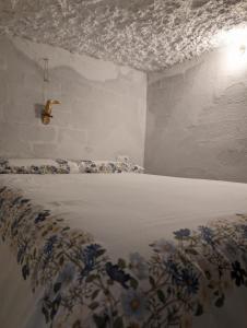 a bedroom with a white bed with blue flowers on it at Gaiamoment La casa la panadera in Alcalá del Júcar +12 photos