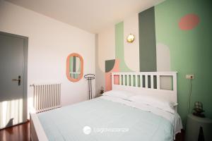 una camera con letto bianco e strisce verdi e bianche di Specchio sul Lago a Manerba del Garda Altre 44 foto