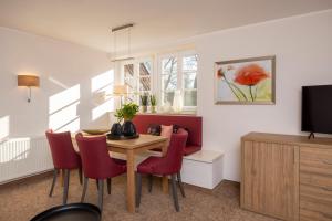 un soggiorno con tavolo da pranzo e sedie rosse di Parkhotel Hohenfeld Münster a Münster
