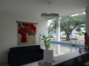 a living room with a blue couch and a window at Pousada Santo André - O Apóstolo in Juazeiro do Norte