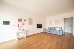 - un salon avec un canapé bleu et des peintures dans l'établissement Casa Rosy, à Olbia