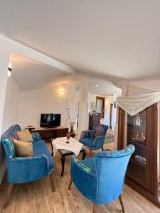 a living room with blue chairs and a table at Mavi & Ani Pansiyon in Antalya