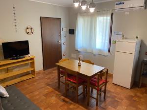 サンタンナ・アッレージにあるSax's houseのテーブルと冷蔵庫のあるリビングルーム