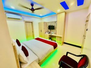 a bedroom with a bed and a ceiling with blue lights at Hotel Shankara Residency in Varanasi