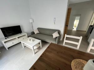 a living room with a couch and a tv and a table at Apartamento La Placeta in Alameda