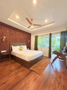 a bedroom with a bed and a ceiling fan at Wild Stories Resort, Munnar in Anachal