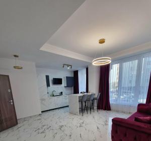 a kitchen and a living room with a table and chairs at Gonbuilding Residence in Suceava