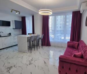 a living room with a red couch and a kitchen at Gonbuilding Residence in Suceava