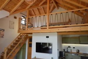 a living room with a loft with a large tv at Montana Goc in Goč
