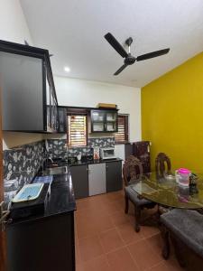 a kitchen with a table and a ceiling fan at Krishnalayam Heritage Villa in Elimala