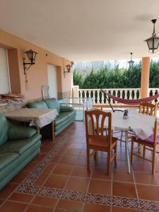 a living room with a couch and a table and chairs at Villa CiTe- jardines/BBQ/terrazas/ para familias in Teruel