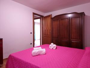 a bedroom with a pink bed with towels on it at Residenze Pedrame in Budoni +96 photos