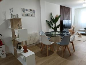 a living room with a glass table and chairs at Bahía Ferry Tranquilo, con Parking y Desayuno Casero en el Centro in Santander