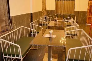 a row of tables and chairs in a room at Hotel Rajmahal Palace Bhimashankar pune in Taleghar