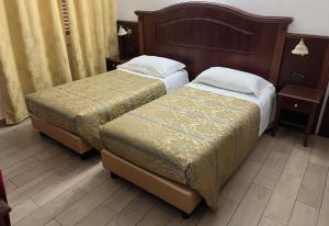 two beds sitting in a hotel room at Hotel Valganna in Milan