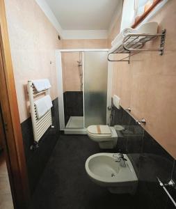 a bathroom with a shower and a toilet and a sink at Hotel Valganna in Milan