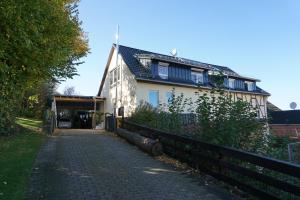 a house with a fence next to a street at Ferienwohnung Am alten Holzweg in Endlichhofen