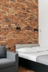 a bedroom with two beds and a brick wall at Native Apartments Długa 24I3 in Kraków +24 photos