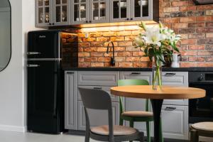 a kitchen with a table with a vase of flowers at Native Apartments Długa 24I3 in Kraków