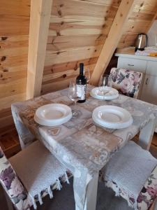 a table with two plates and wine glasses on it at Squirrel's House in Žabljak +10 photos