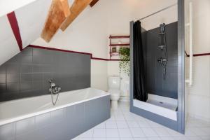 a bathroom with a bath tub and a toilet at La Demeure de la Poterie, Wimille & Wimereux in Wimille +98 photos