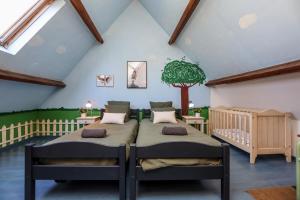 two beds in a room with a tree on the wall at La Demeure de la Poterie, Wimille & Wimereux in Wimille