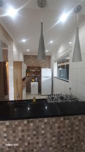 a kitchen with a stove and a refrigerator at Cantinho Caiçara in São Sebastião +5 photos