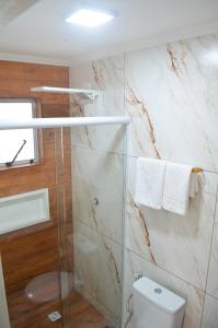 a bathroom with a toilet and a glass shower at Da Matta House Estilo e Conforto a 8km de Capivari in Campos do Jordão +73 photos