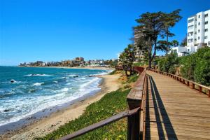 un paseo marítimo de madera que conduce a una playa con un edificio en SR Colinas del Faro 2 BDR in Mijas Costa, en Mijas Costa