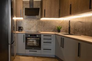 Una cocina con gabinetes blancos y un horno de estufa. en The 9 Apartments, en Przemyśl