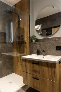 Un baño con lavabo y ducha con espejo. en The 9 Apartments, en Przemyśl 15 fotos más