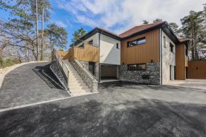 a house with a staircase in a driveway at La Villa Léo face au Centre Equestre et Piscine in Neufchâtel-Hardelot